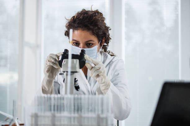 istock Portrait of focused female scienitst analyzing a sample under a microscope 1441692960