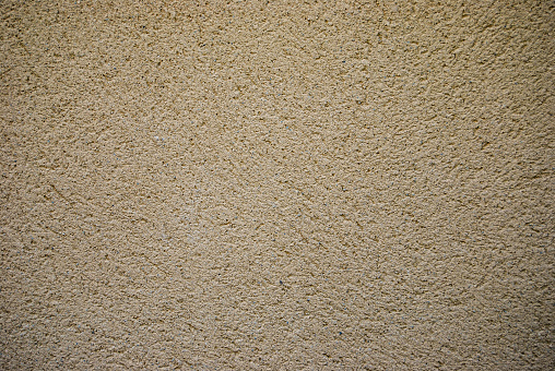 Wall of a facade with monolayer of sandy texture