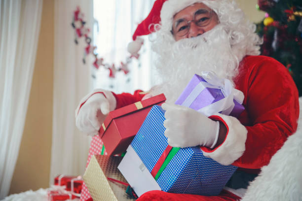 babbo natale che tiene la scatola regalo e la borsa regalo alle persone durante l'evento del giorno di natale. - gift human hand box giving foto e immagini stock