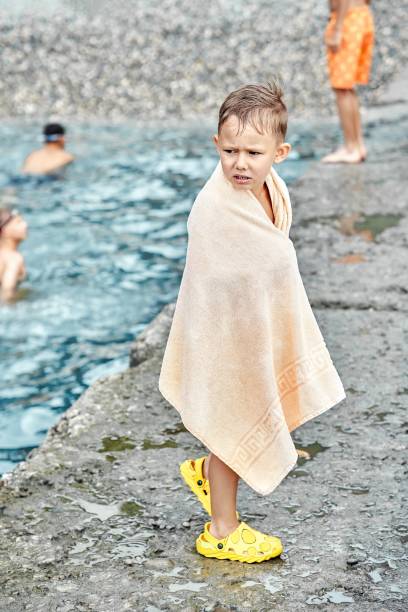 istock Small boy wrapped with towel gets cold after swimming 1441705186