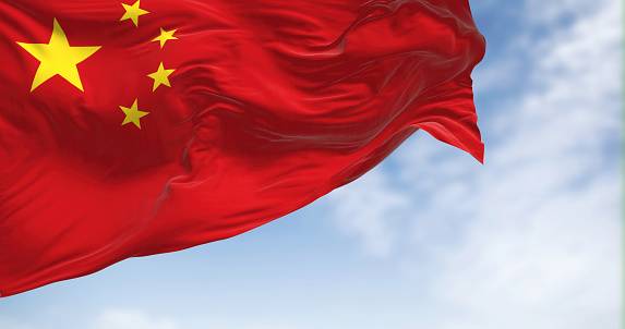 Close-up view of the China national flag waving on a clear day. People's Republic of China is a country in East Asia. Fabric textured background. 3D illustration