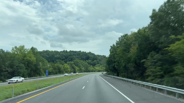 Car Point of View Shot of Driving along Treelined Interstate 65 in Middle Tennessee Under a Partly Cloudy Sky