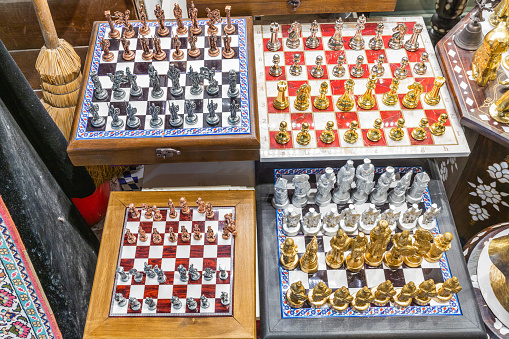 Gold and marble chess set by a swimming pool