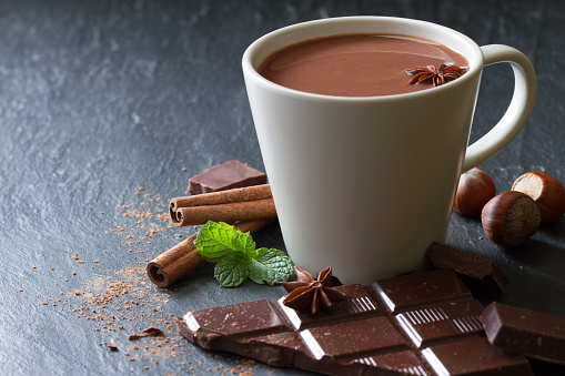 Hot chocolate in cup with additives concept background