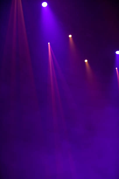 fasci di luce viola dai riflettori del palcoscenico su uno sfondo scuro. - laser lasershow exhibition dancing foto e immagini stock
