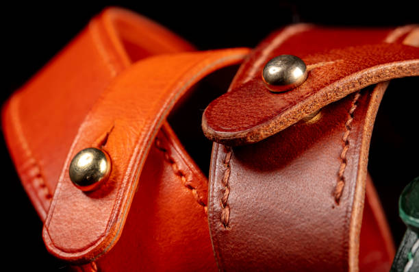 Part of a leather product or belt with a metal rivet on a black background. Part of a leather product or belt with a metal rivet on a black background. leather pocket clothing hide stock pictures, royalty-free photos & images