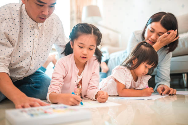 istock Happy Asian Parents Lying On The Floor With Their Two Young Daughters 1441714979