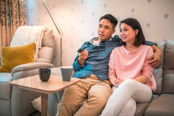 istock Affectionate Young Chinese Couple Watching TV At Home 1441715676