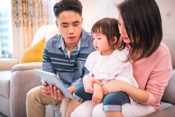 istock Young Asian Parents With One Child Using A Digital Tablet At Home 1441715681