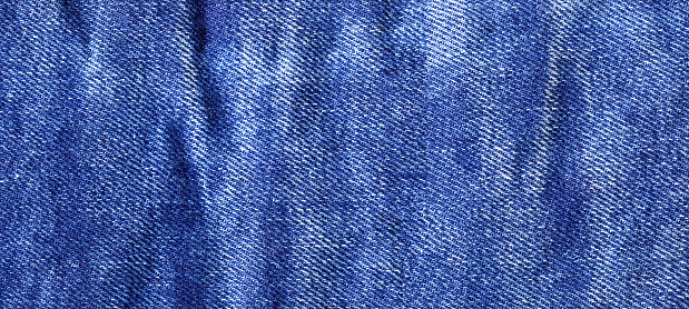 Jeans fabric texture. High quality stock photo. The connection of the fibers of the fabric.