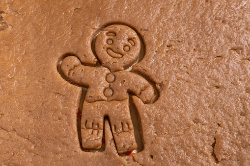 Gingerbread man carved from raw gingerbread dough. Making homemade gingerbread cookies. Christmas Cookies.