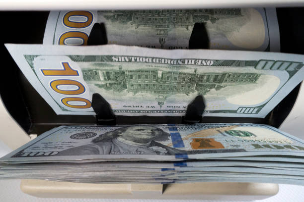 istock Electronic money counter machine is counting is counting the American hundred-dollar US dollars banknotes 1441719113