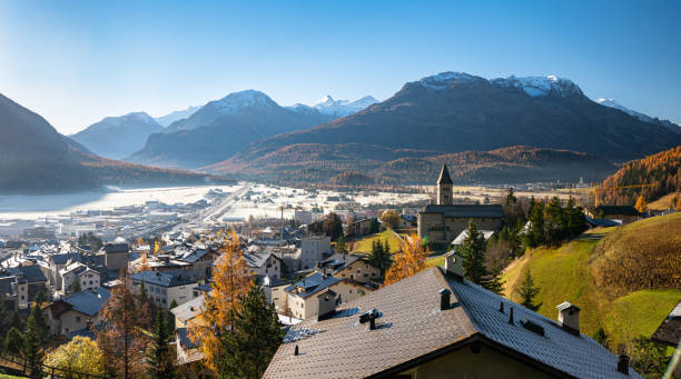 Scenic view of the town of Samedan, Switzerland on a sunny morning Wide view of the town of Samedan in Engadine Valley and the entrance to Bernina Valley, Switzerland on a sunny autumn morning. Golden larch trees on the mountain slopes and ripe on the valley floor. samedan stock pictures, royalty-free photos & images