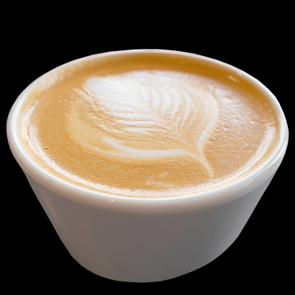 cup of cappuccino coffee with a pattern on the crema isolated on a black background