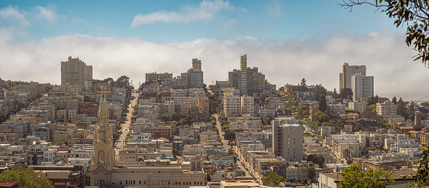 Panorama of San Francisco with the fog, behind the buildings, on the way, San Francisco, California, United States of America.