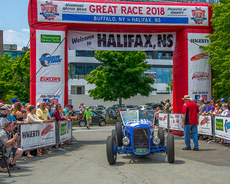 Halifax, Nova Scotia, Canada -  July 1, 2018 : 1932 Ford Model A Speedster, Team 9  from Vermont, USA crossing the finish line for Hemmings Motor News Great Race 2018 while people crowd around to watch, Lower Water Street, Halifax, NS, Canada.