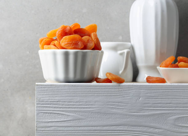Dried apricots on a white wooden table.