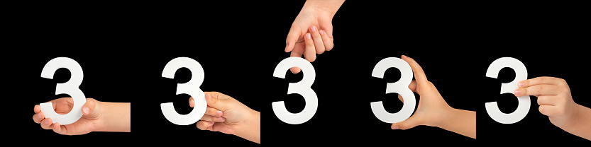 number three in hand isolated on black background. Number three in a child's hand on a black background. A great set to insert into a project or design