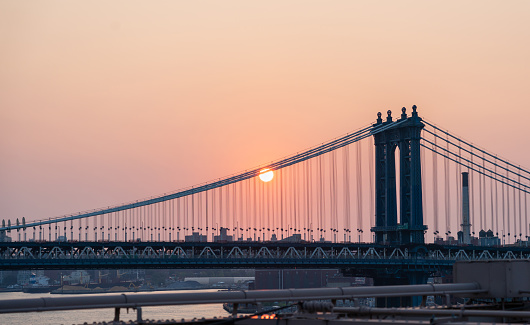 Manhattan Bridge at dawn and some disc of the rising sun.