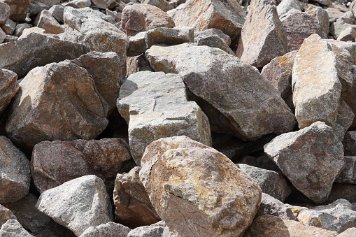 Close up view on light colored pile of Stones as building materials. Picture can by use as background and has a lot of copy space.