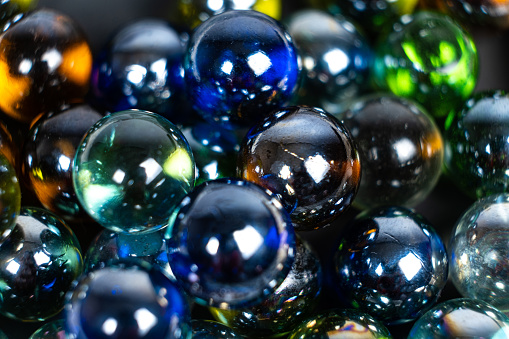 Lots of blue and green glass balls, beads on a white background, close-up.