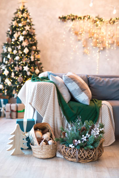 istock Interior of modern studio living room with comfortable sofa decorated with Christmas trees and gifts. 1441731501