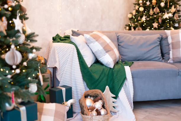 istock Interior of modern studio living room with comfortable sofa decorated with Christmas trees and gifts. 1441731516