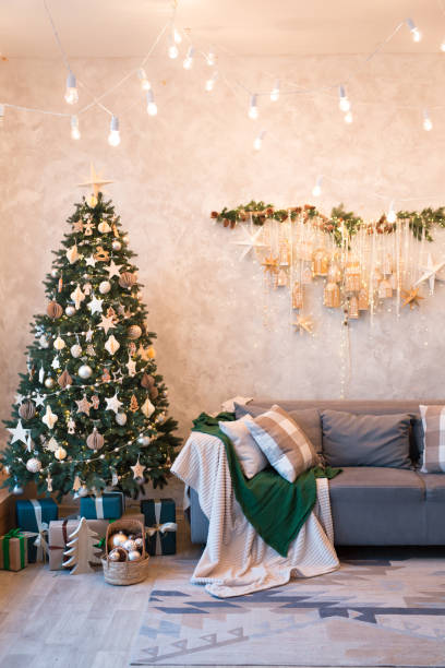 istock Interior of modern studio living room with comfortable sofa decorated with Christmas trees and gifts. 1441731559