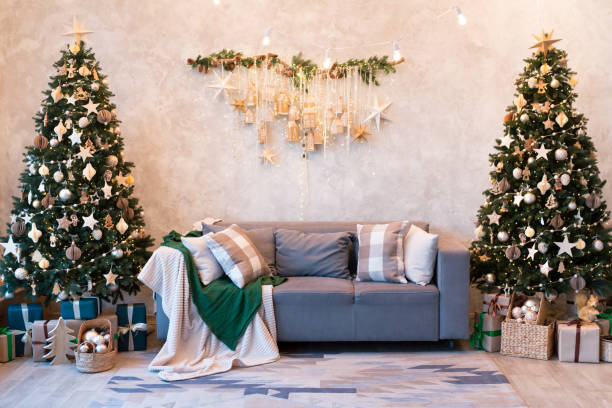 istock Interior of modern studio living room with comfortable sofa decorated with Christmas trees and gifts. 1441732081