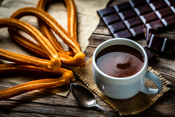 istock Churros and hot chocolate on rustic wooden table. 1441732101