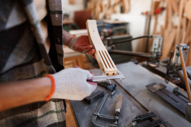 Casually clothed carpenter taking measures with Vernier calliper