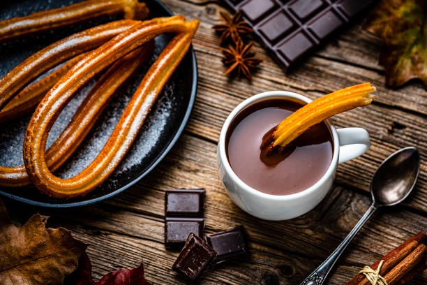 istock Churros and hot chocolate on rustic wooden table 1441732202