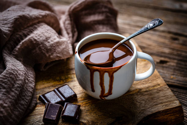 istock Mug of melting hot chocolate on rustic wooden table. 1441732204