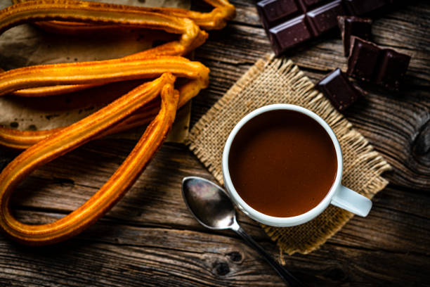 churros y chocolate caliente disparados desde arriba sobre una mesa de madera rústica. - churro chocolate cup sweet food fotografías e imágenes de stock