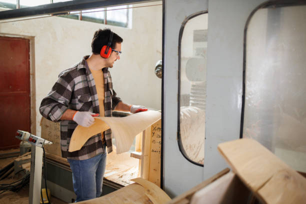 istock Young casually clothed carpenter with a back of a chair in a workshop 1441733774