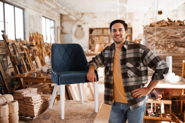 Portrait of young casually clothed chairmaker in a workshop