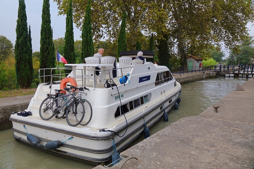 Boat crossing locks on historic Canal du Midi in France. Canal du Midi is a UNESCO World Heritage Site.