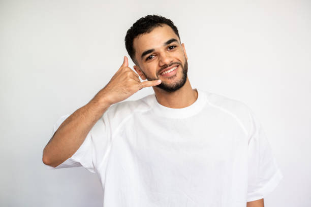 istock Portrait of happy young man making phone gesture 1441739363