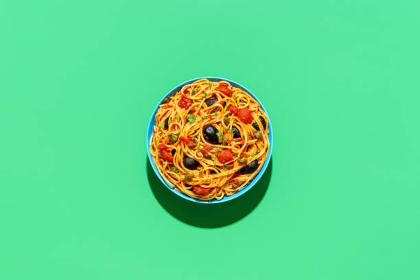 istock Vegan pasta, spaghetti puttanesca, top view on a green background 1441740306