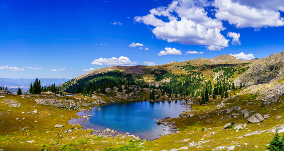 Alpine Lake Mountain Landscape in Summer - Scenic high alpine area with mountain peaks and clear blue lake on sunny day. Beauty in nature tranquil scene.