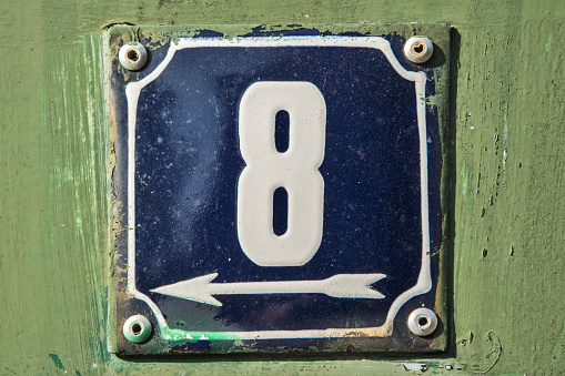 Weathered grunge square metal enameled plate of number of street address with number 8