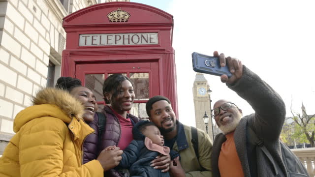 Black family capturing London memory with smart phone