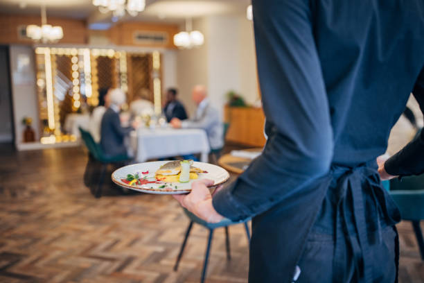 istock Waiter bringing food for guests 1441745439
