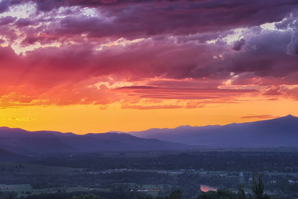Breathtaking sunset with oranges and pinks and a reflection off the Bitterroot River during June in Missoula