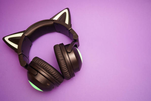 istock Black wireless headphones are highlighted on a purple background. Cosplay accessory. Wireless gaming headset with cat ear. Different colors of illumination. 1441748631