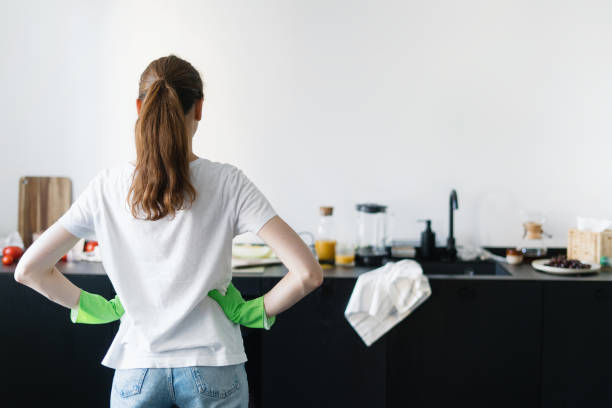 istock woman in kitchen with dirty countertop, kitchenware and utensils 1441748647