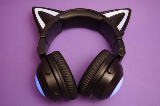 istock Black wireless headphones are highlighted on a purple background. Cosplay accessory. Wireless gaming headset with cat ear. Different colors of illumination. 1441748649