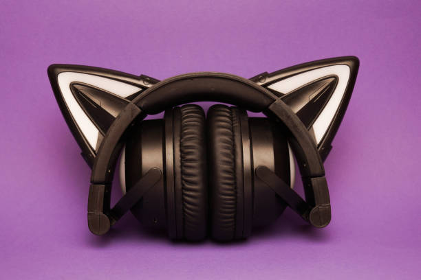 istock Black wireless headphones are highlighted on a purple background. Cosplay accessory. Wireless gaming headset with cat ear. Different colors of illumination. 1441748657