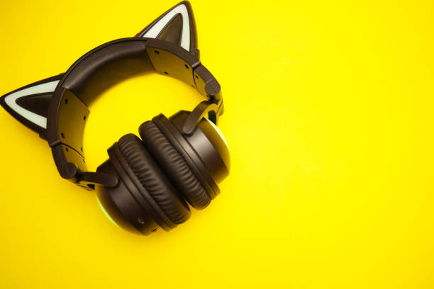 istock Black wireless headphones are highlighted on a yellow background. Cosplay accessory. Wireless gaming headset with cat ear. Different colors of illumination. 1441748690