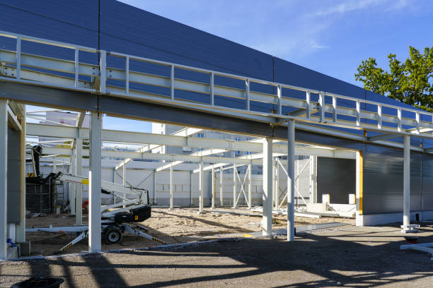 istock Unfinished steel construction frame of a new modern warehouse with blue sandwich panel wall 1441749873